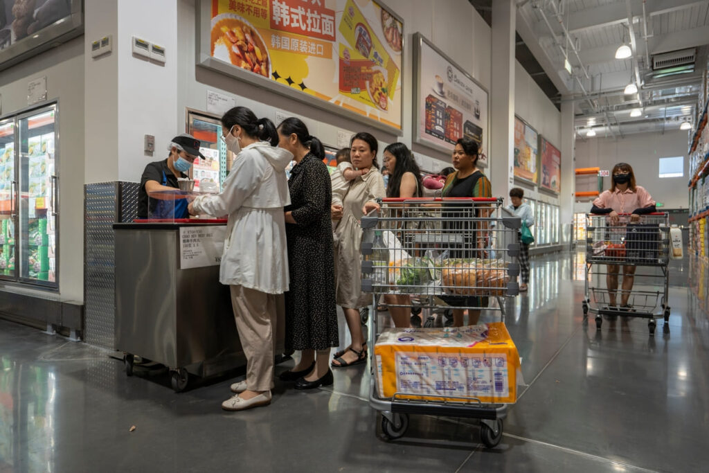 Shoppers wait in line at a sample station for free