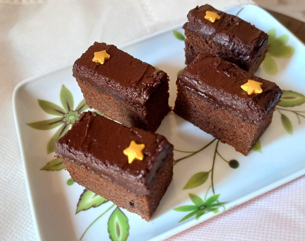chocolate fudge, chocolate cake with chocolate icing served in a white square plate