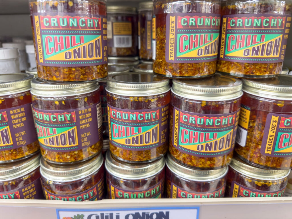 A view of several jars of Trader Joe's crunchy chili onion condiment.