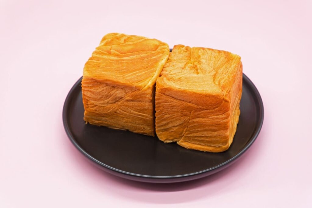 Pink background nutritious breakfast hand torn milk toast bread