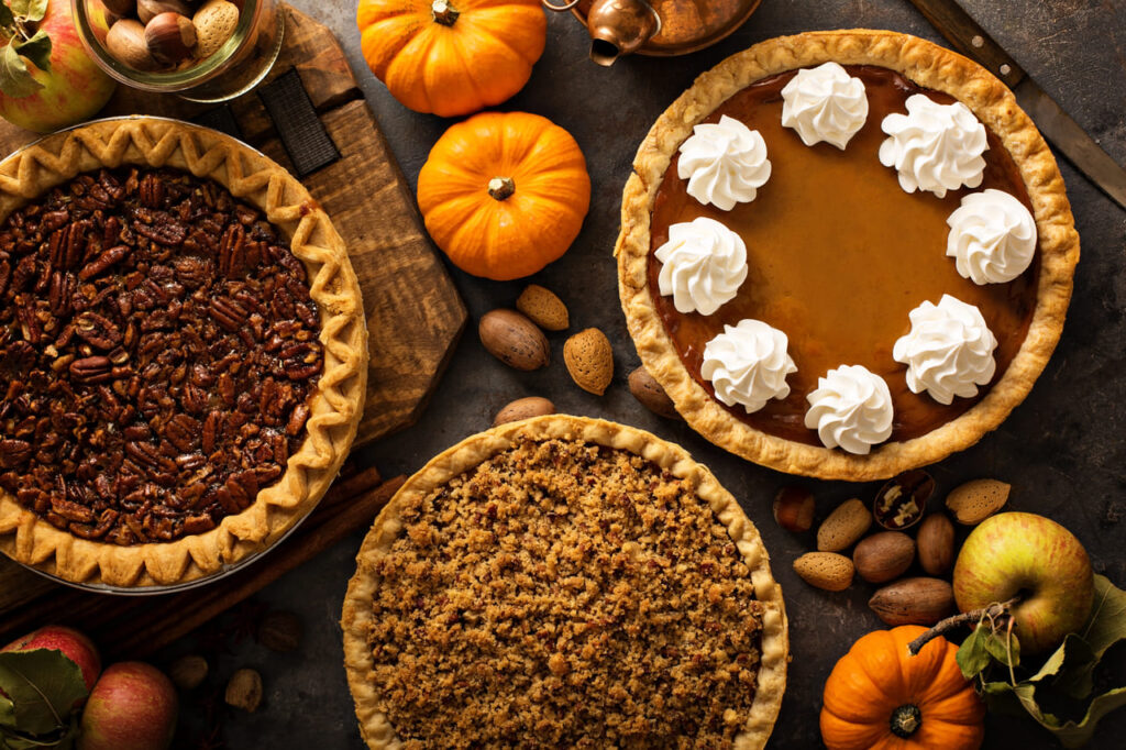 Fall traditional pies pumpkin, pecan and apple crumble pie overhead shot