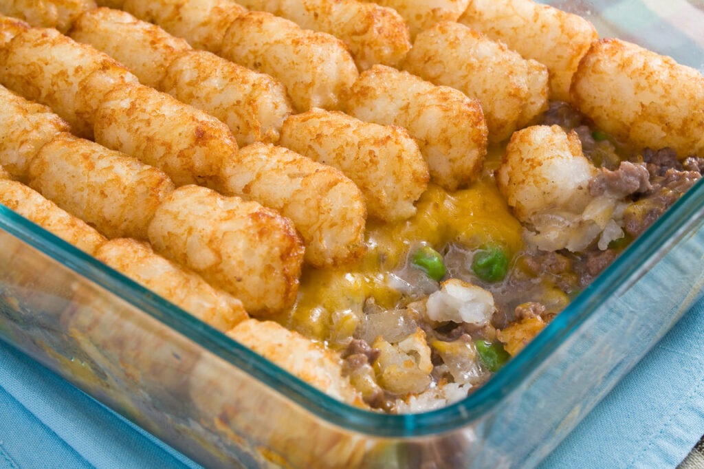 Tater Tots Casserole - Casserole made of tater tots, cheddar cheese, ground beef, peas, and onions.