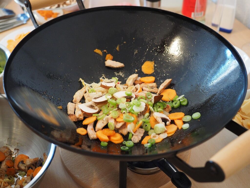 Onions, carrots, celery, and garlic being sautéed in a pan.