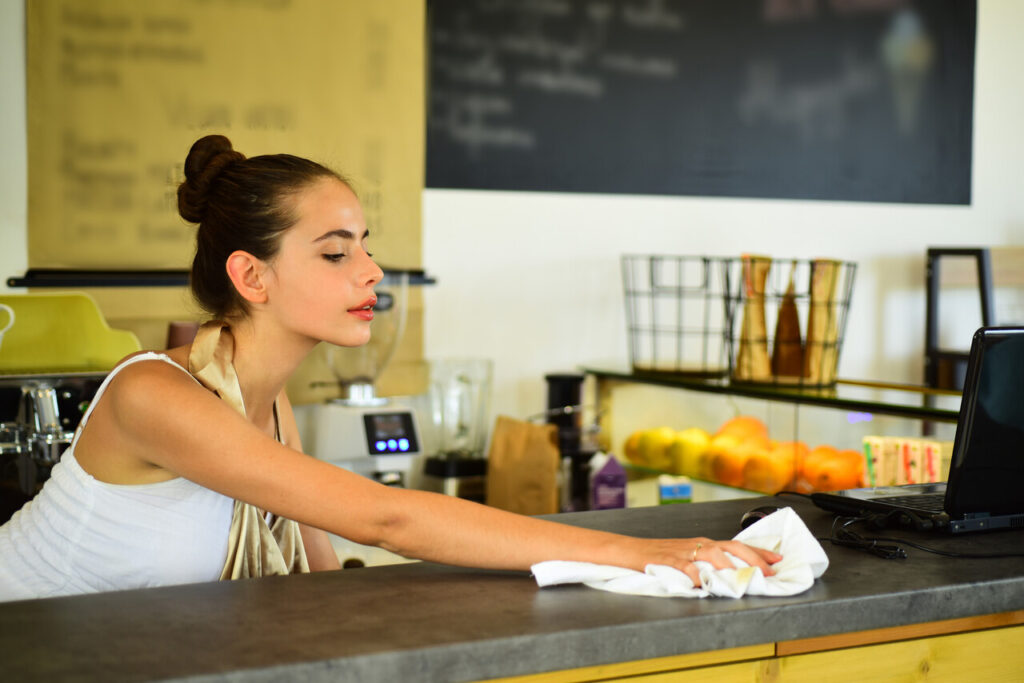 A barista wiping down a messy counter.