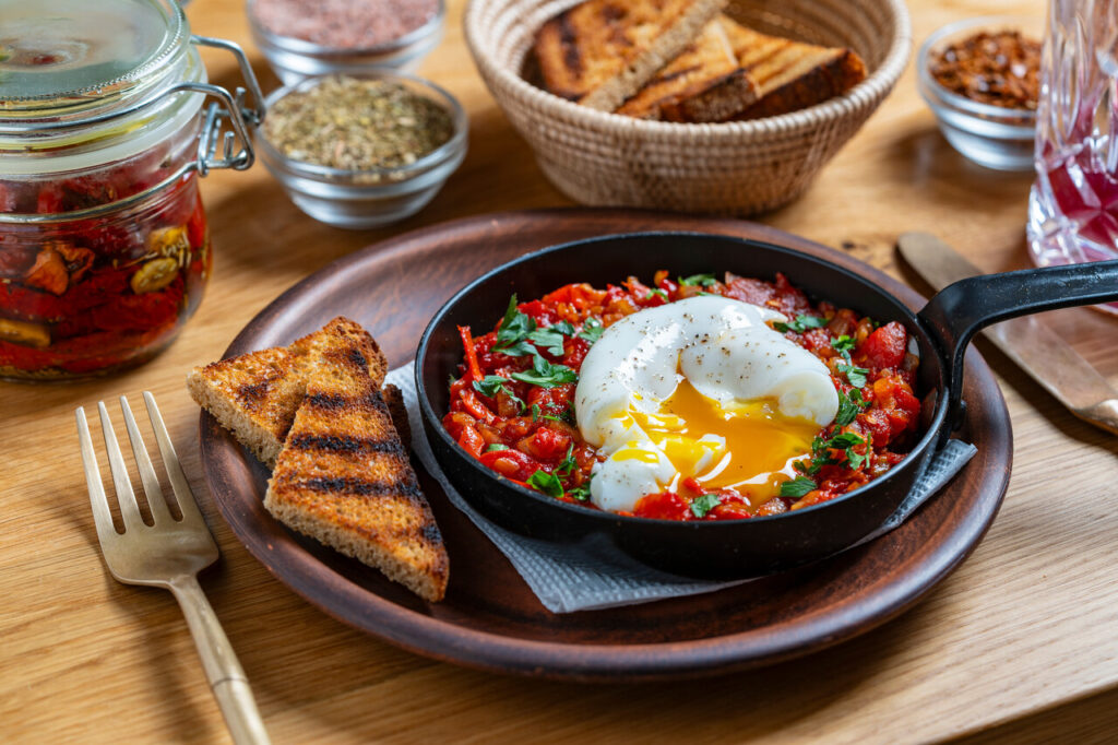 Delicious shakshuka in frying pan for breakfast, close up.