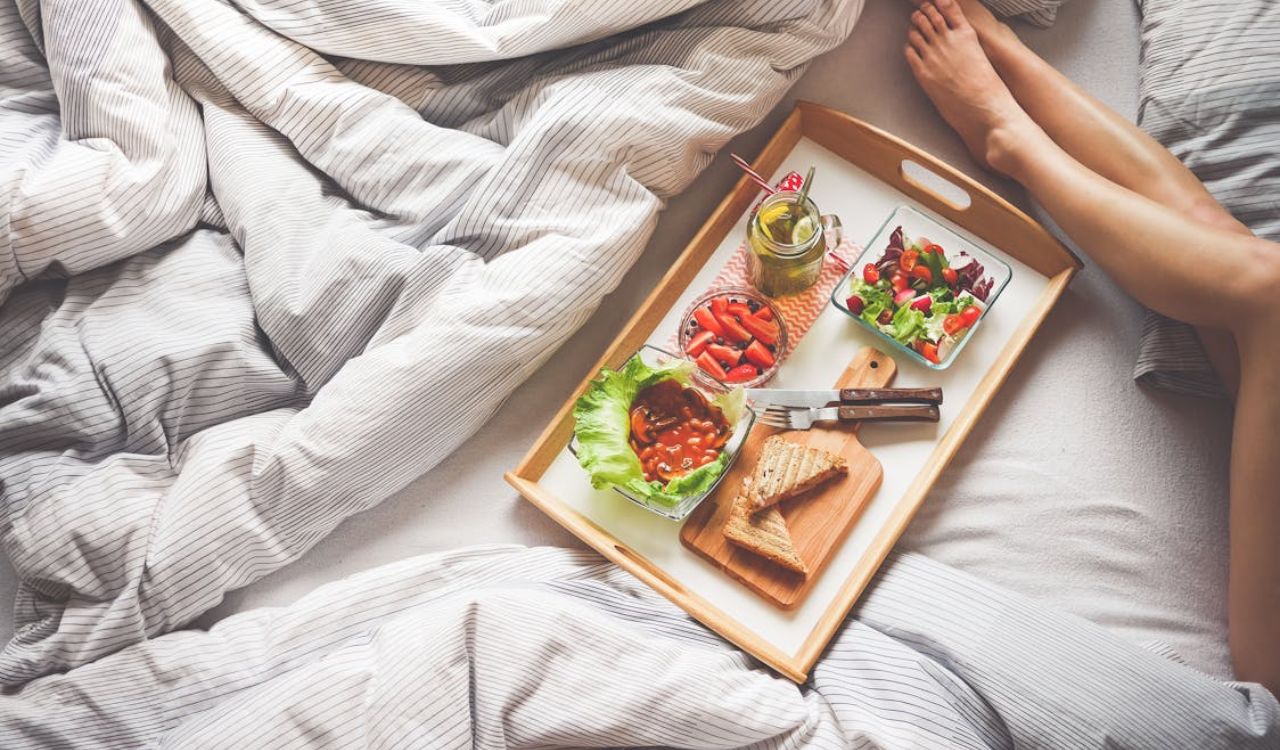 Breakfast on bed beside woman