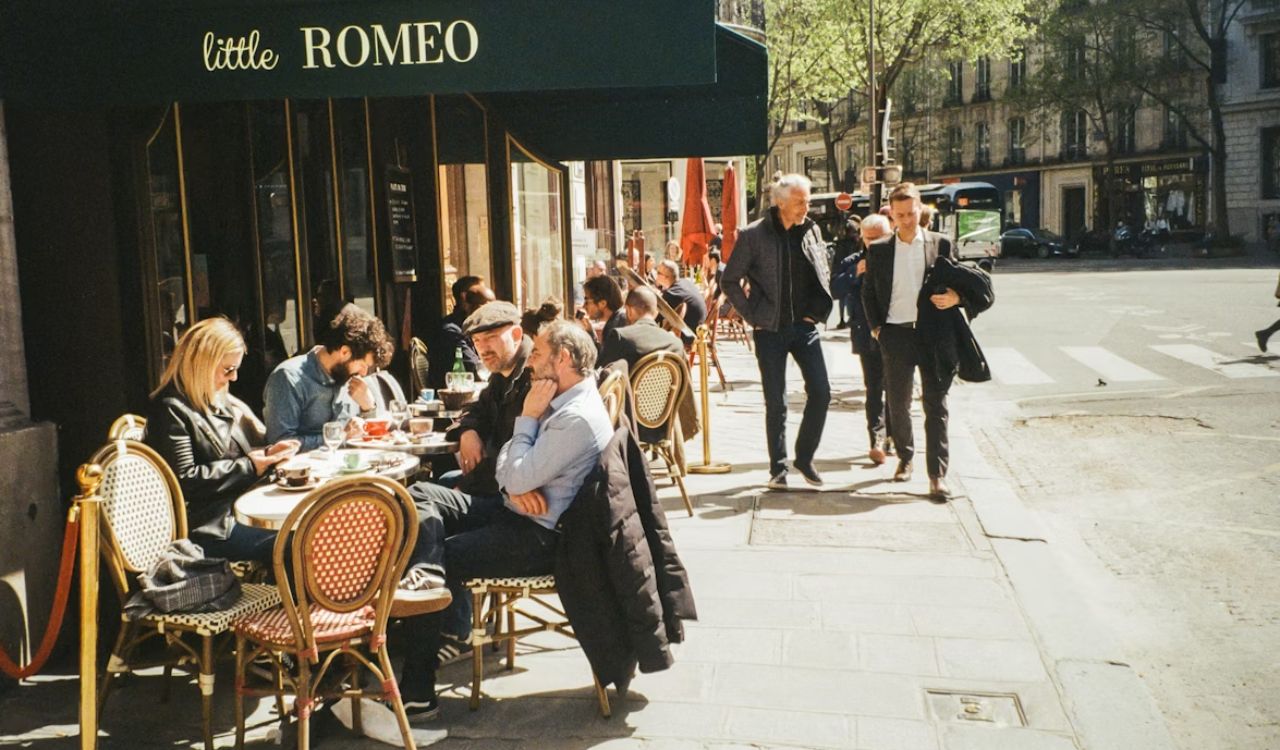 Group of people sitting at a table outside of a restaurant