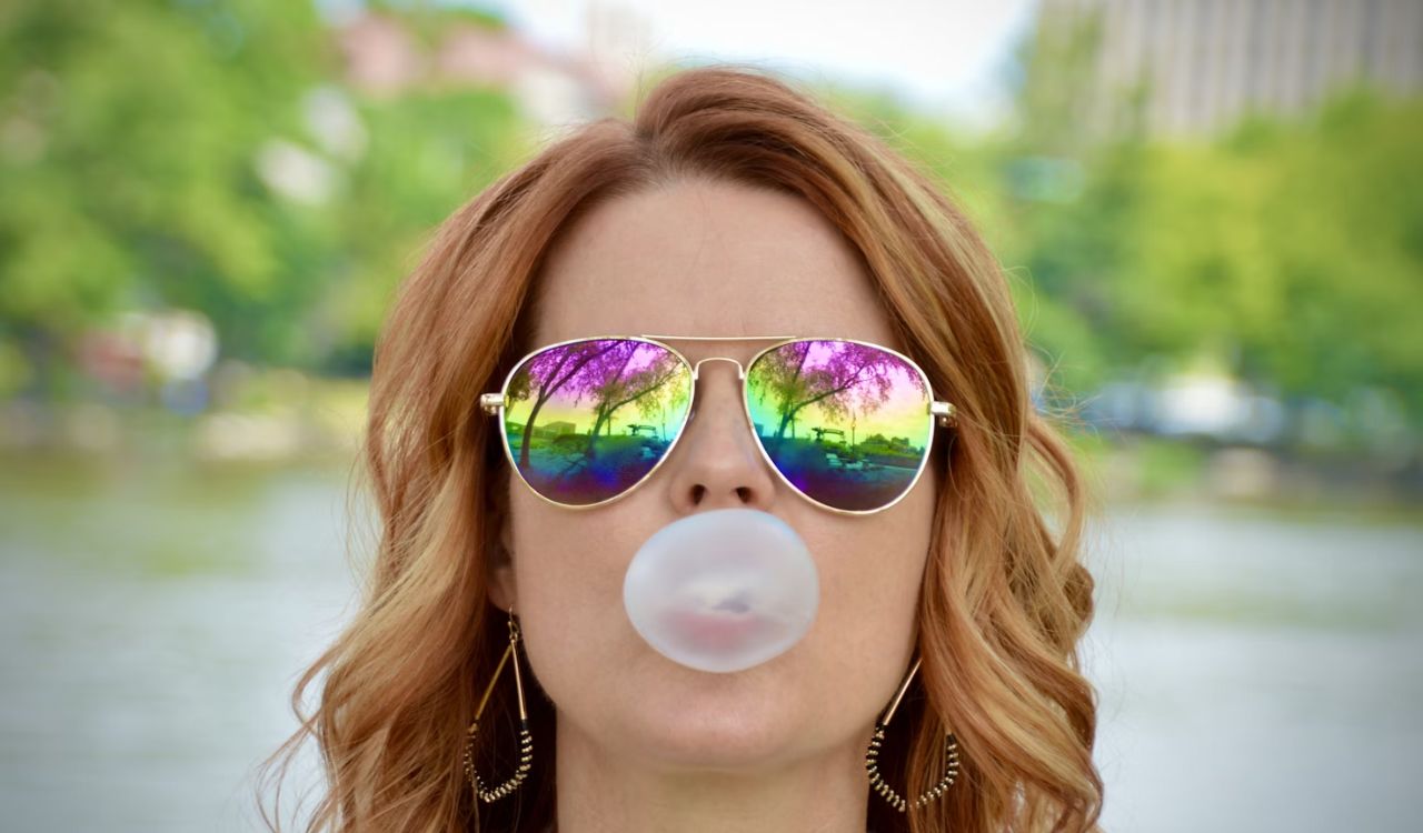 Woman wearing sunglasses with bubblegum