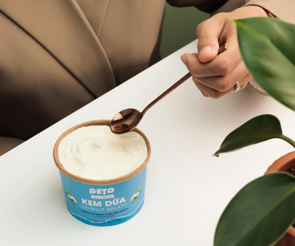 Person Eating Coconut Ice Cream with Spoon