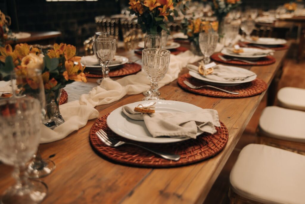 A warmly lit dinner table set for multiple guests