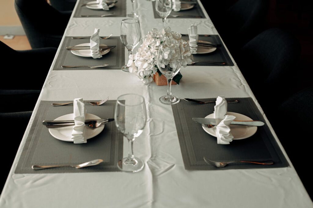 A formal dinner with white tablecloths and silverware