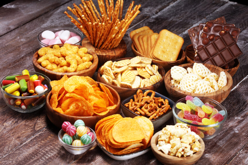 Salty snacks. Pretzels, chips, crackers in wooden bowls.