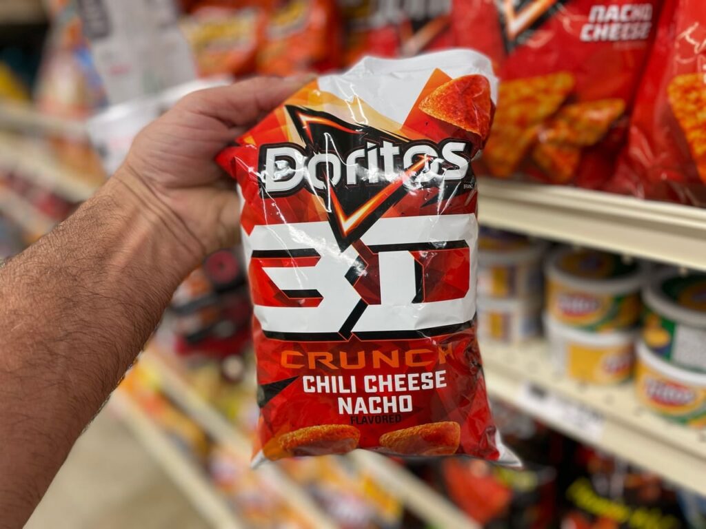Retail grocery store hand holding bag of Doritos 3D