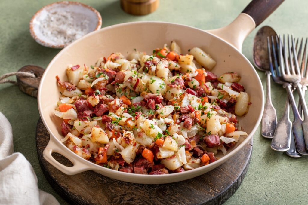 Corned beef hash with potatoes, cabbage and carrot in a cast iron pan