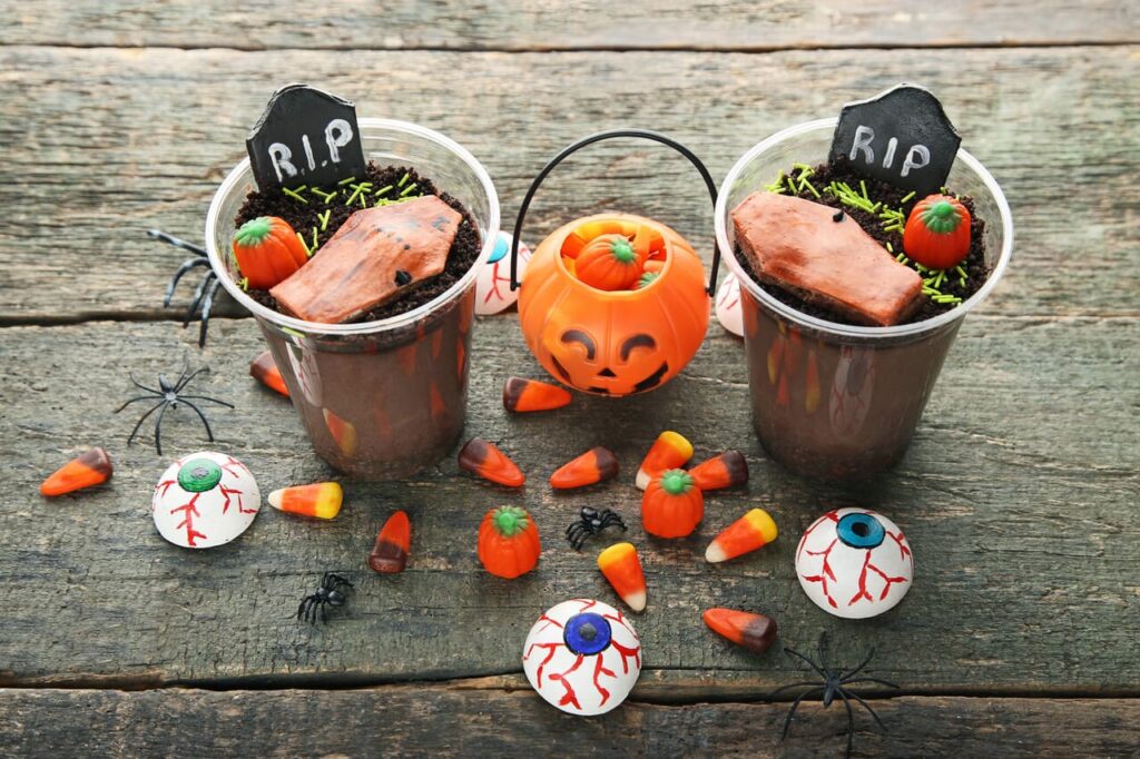 Fresh halloween gingerbread cookies with candies on wooden table