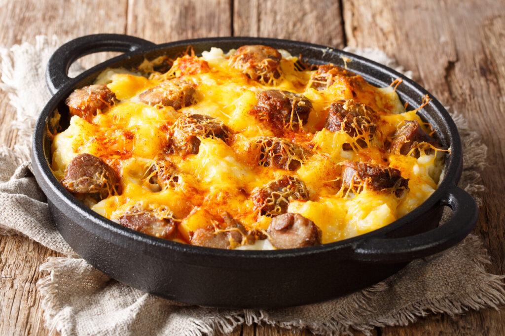 Homemade Jolean's Cheese Potato and Smoked Sausage Casserole closeup on the pan on the table. horizontal