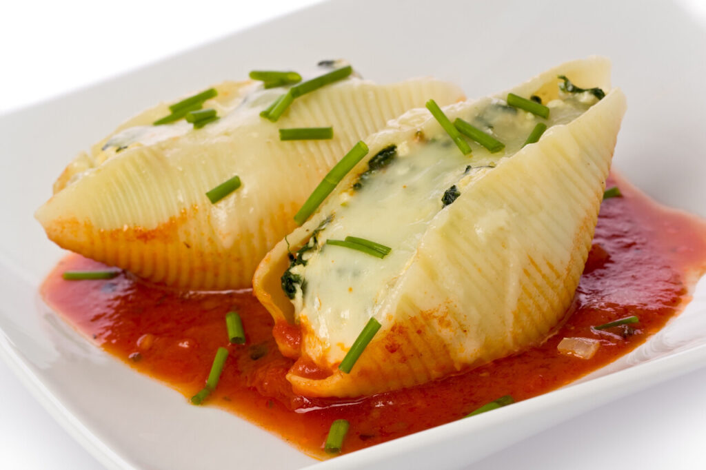 Pasta shells stuffed with swiss chard, ricotta, mozzarela and parmesan cheeses with tomato sauce and chives.
