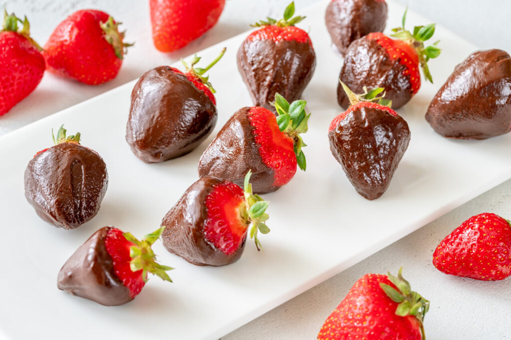 Chocolate-dipped strawberries on the white serving plate
