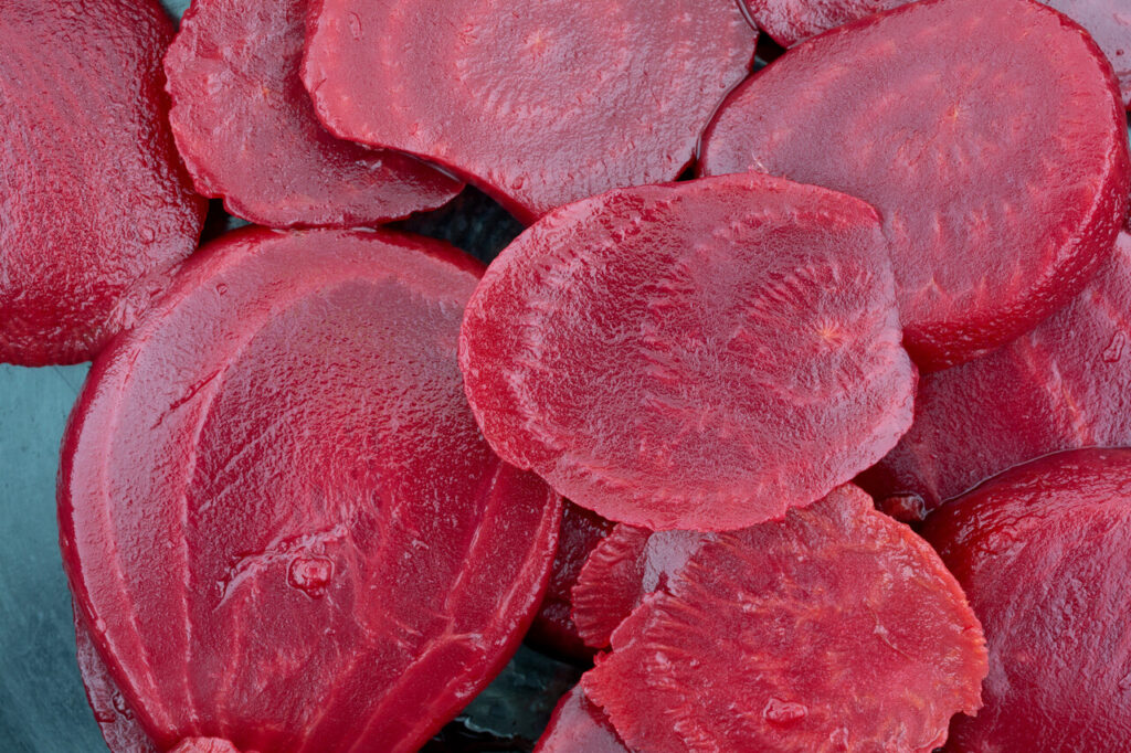 Top close view of canned sliced beets in a cast iron skillet.