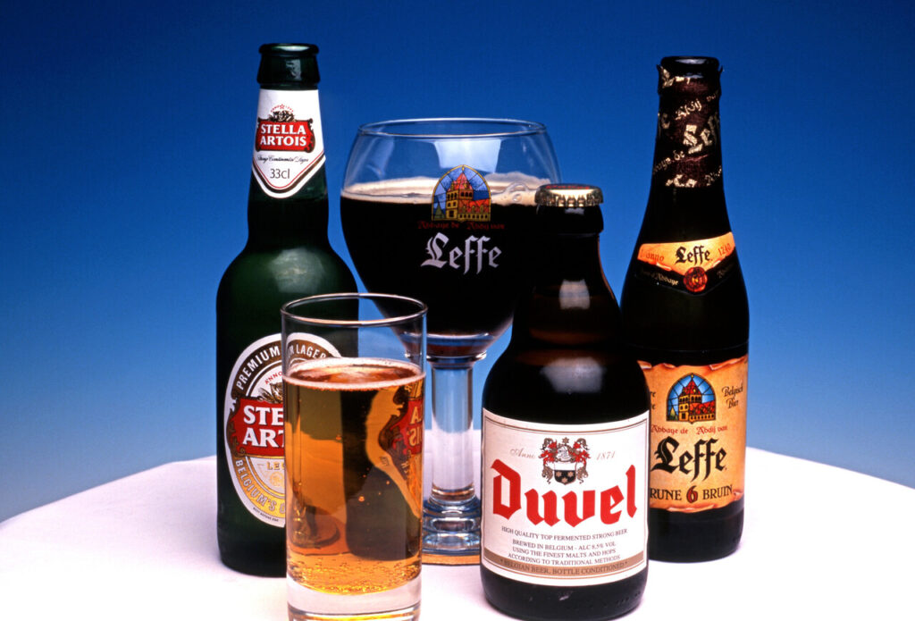 A selection of Belgian beer including Stella Artois, Duval and Leffe with a large glass of Leffe beer.