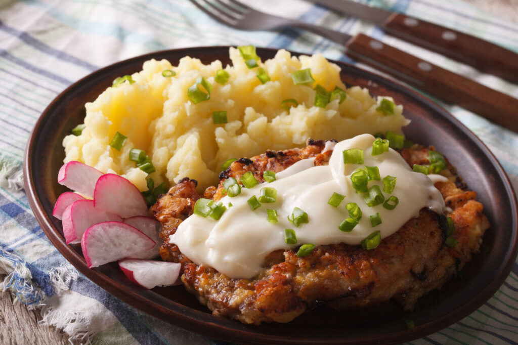 Country Fried Steak with potato garnish on a plate close-up horizontal