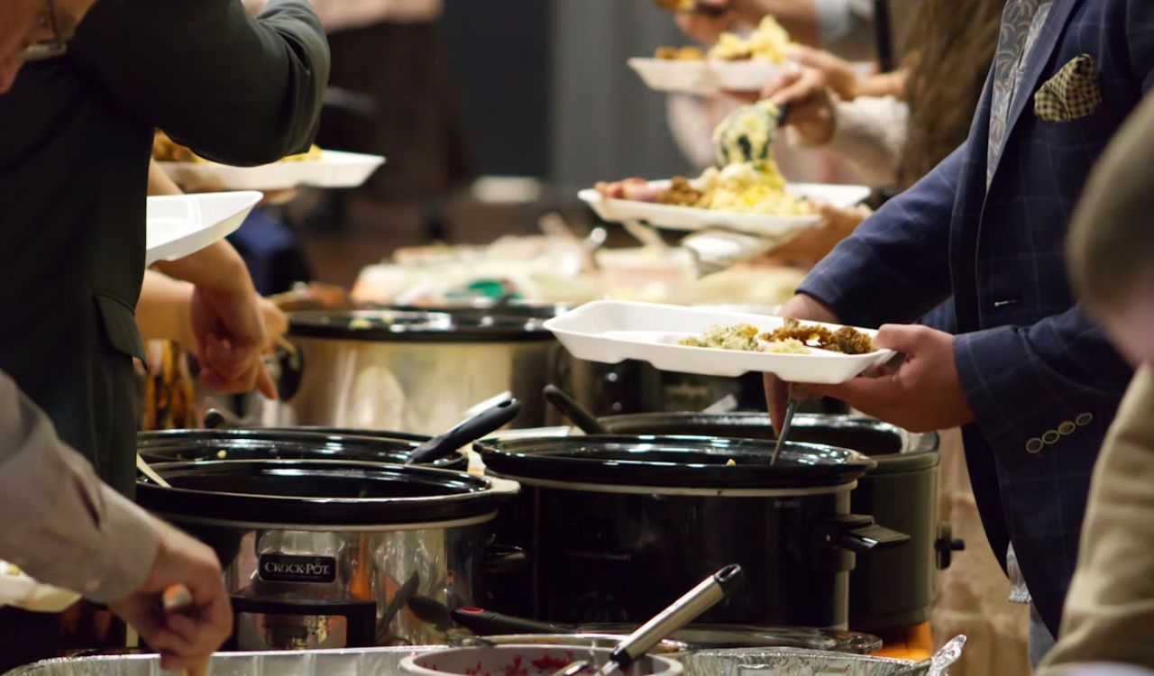 Group of people getting food from crockpots