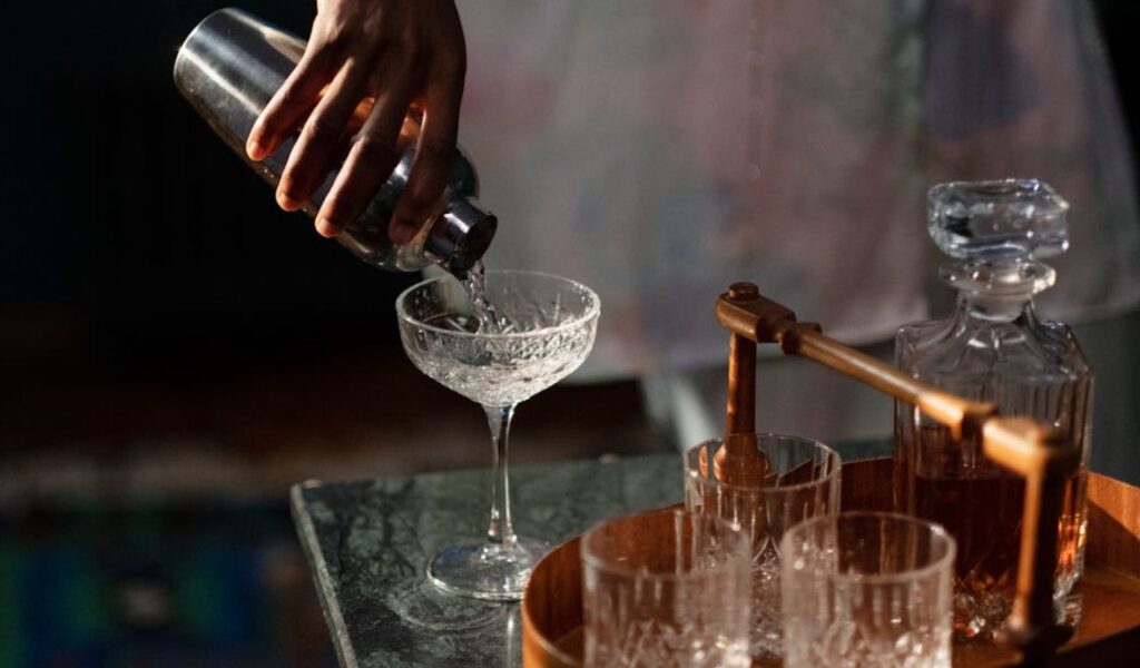 Pouring cocktail into glass from shaker