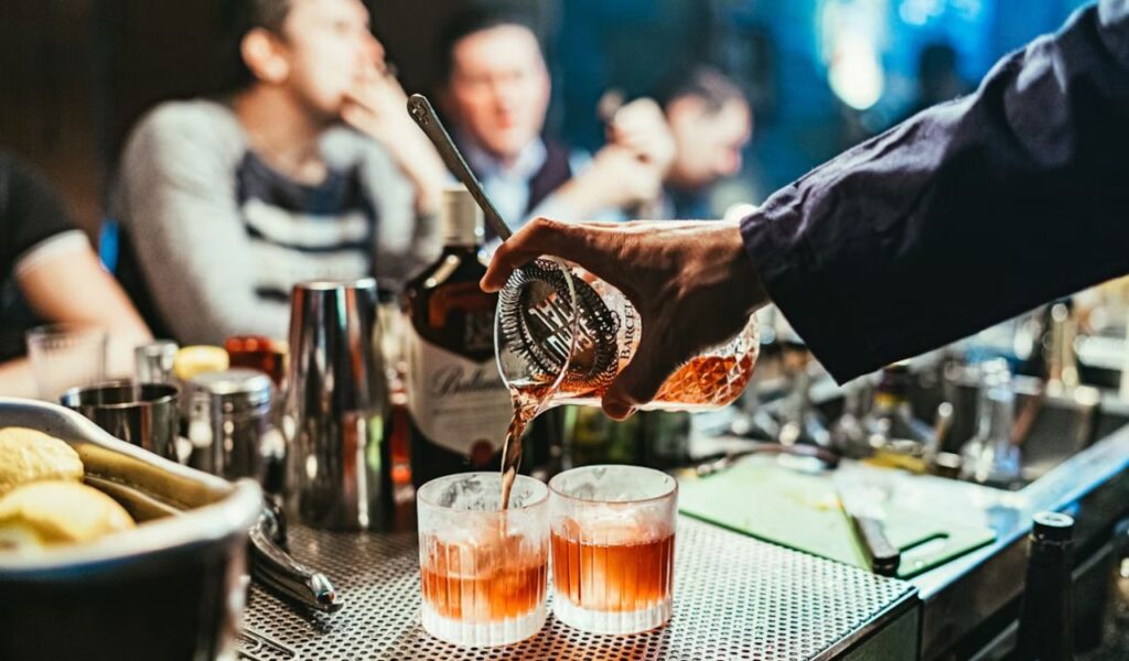Pouring cocktails on glasses