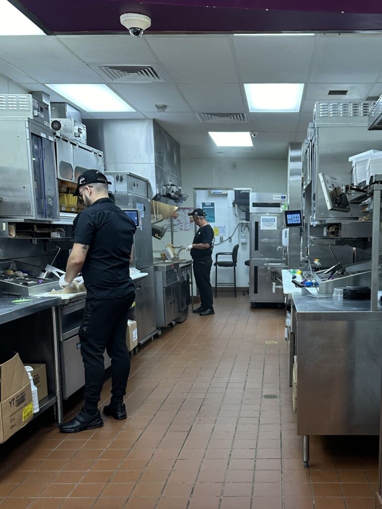 Interior shot of a 1960s Taco Bell kitchen with staff preparing tacos by hand.