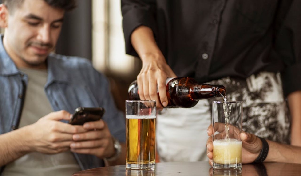 Waiter pouring beer into glass