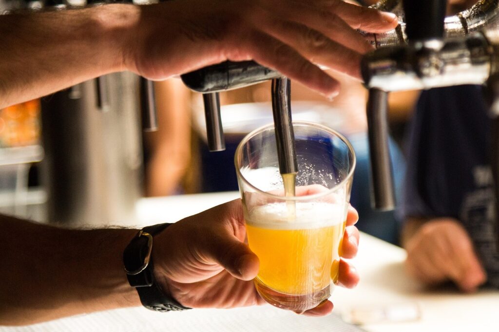 Whisky being poured directly from a barrel tap.