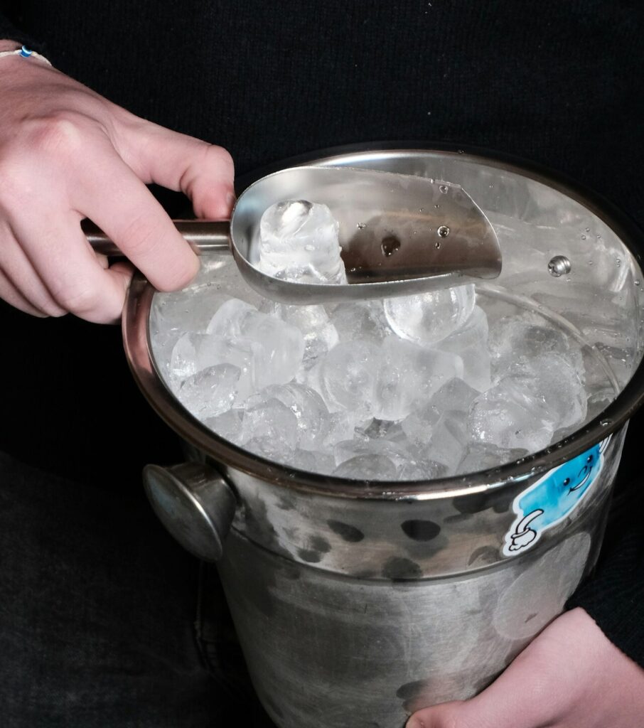Ice falling from a dispenser into a cup, with condensation visible