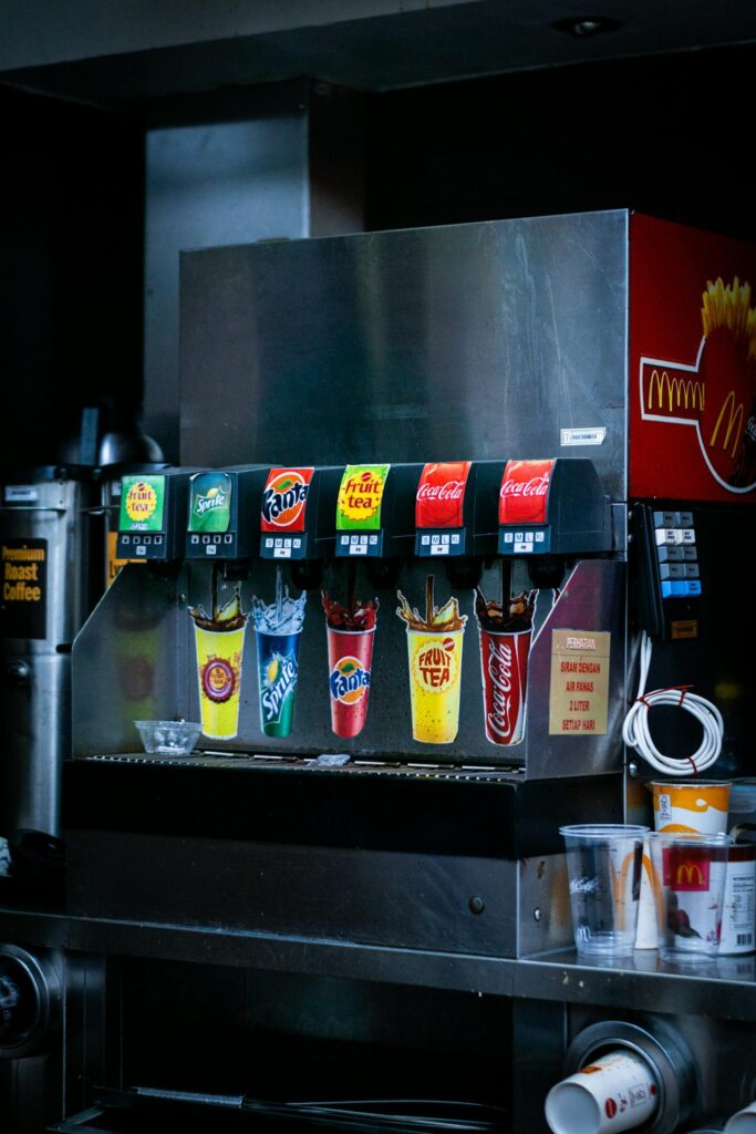 Soda fountain dispensing cola into paper cup.