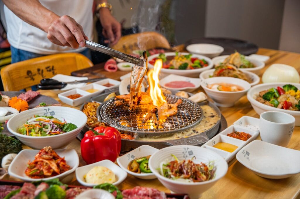 A communal table filled with fusion barbecue dishes from multiple cuisines.