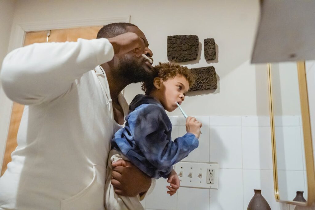 father and son brushing teeth