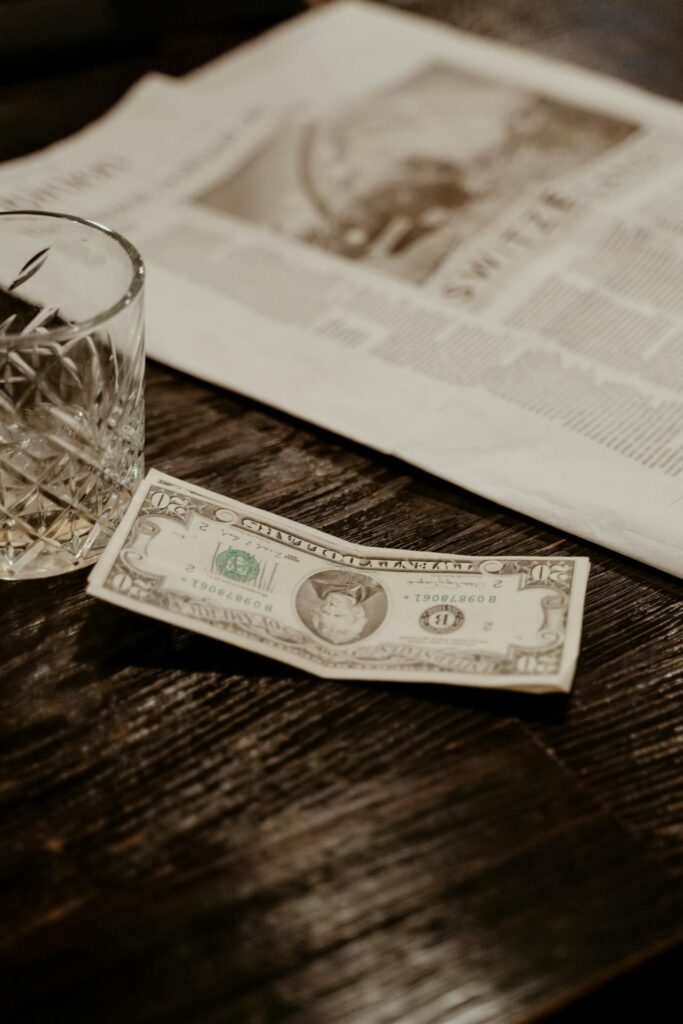 vintage bill folder with cash, table with tip left behind, server collecting payment.