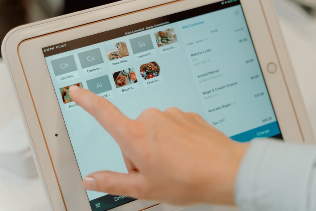 Guest using a mobile app or tablet to browse or order food at a cozy restaurant booth.