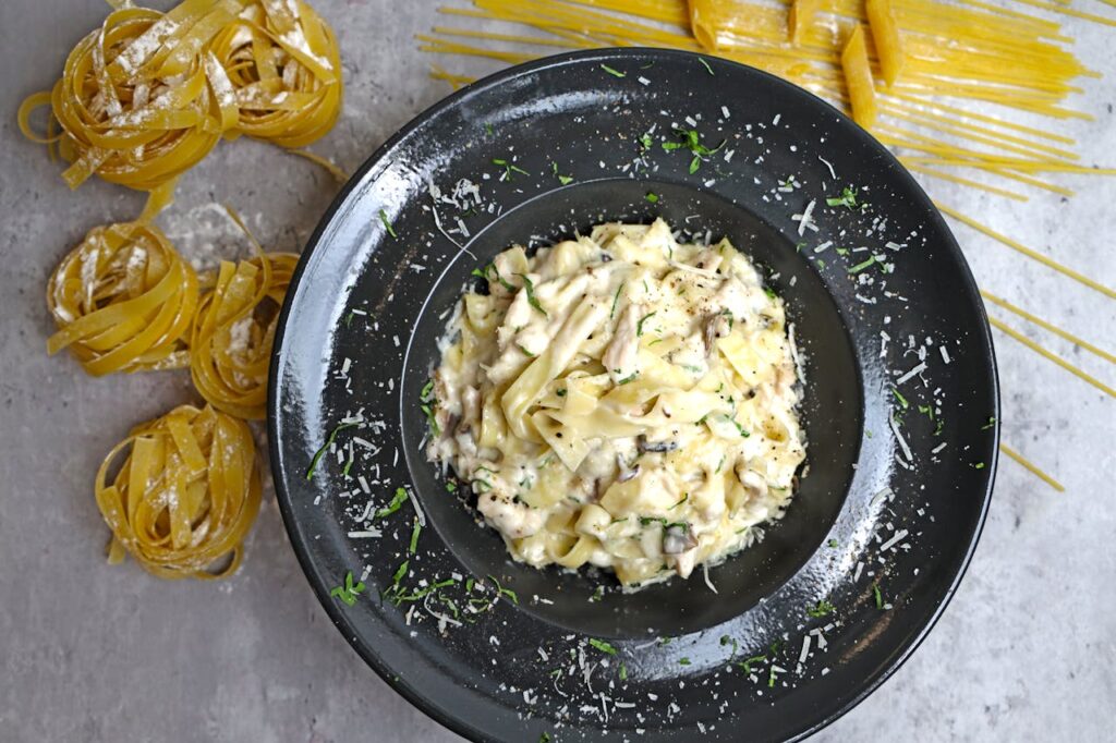 A bowl of lemon spaghetti topped with freshly grated Parmesan and lemon zest.