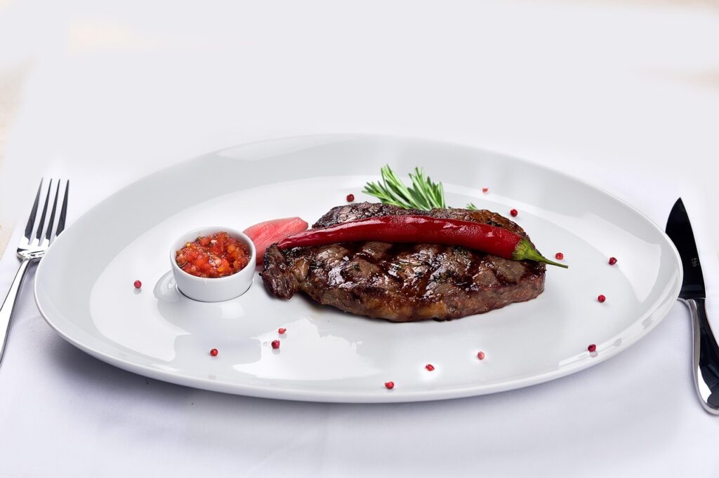 A charred, overcooked steak on a grill.