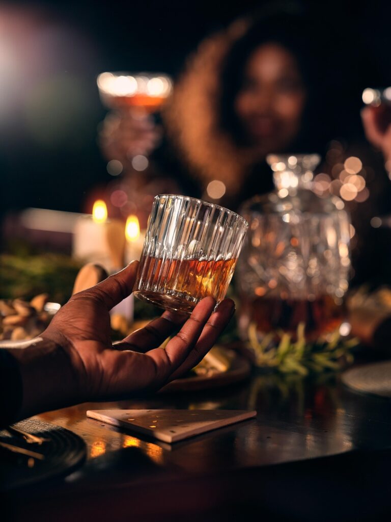 A single dram of whisky on a table with soft evening light.
