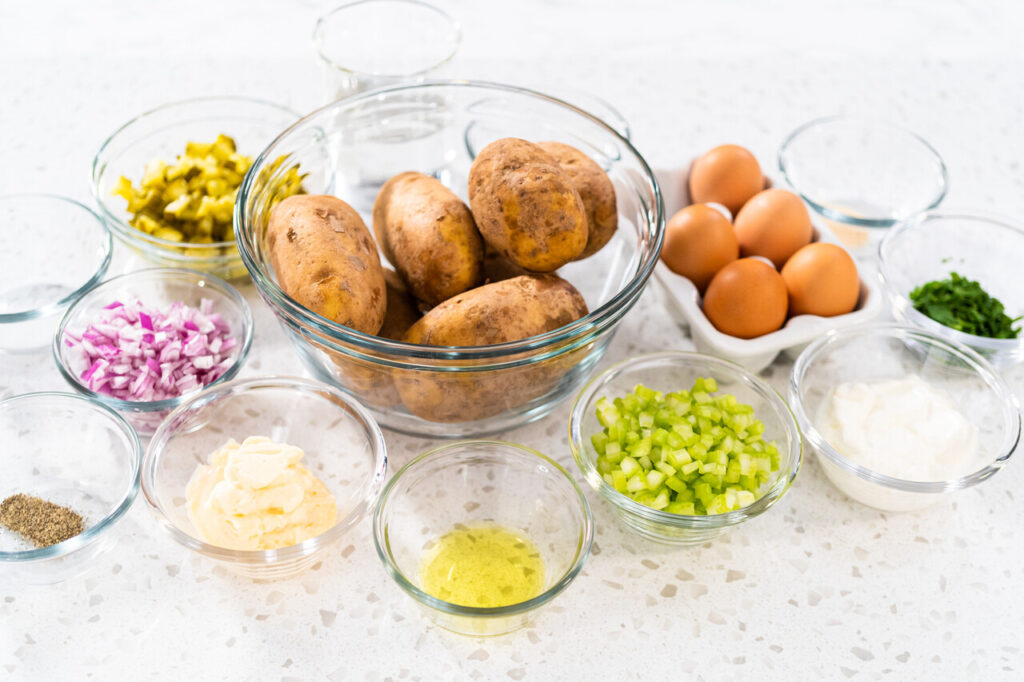 Measured ingredients in glass mixing bowls to make potato salad.