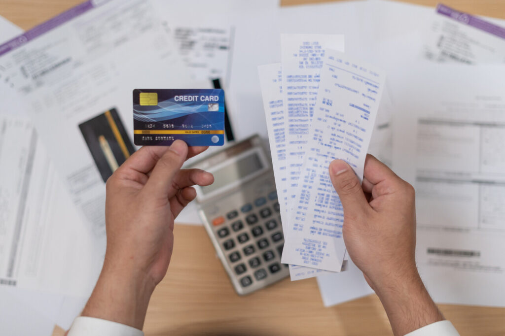 A wallet laid out with a Visa card and debit card beside a Costco receipt.