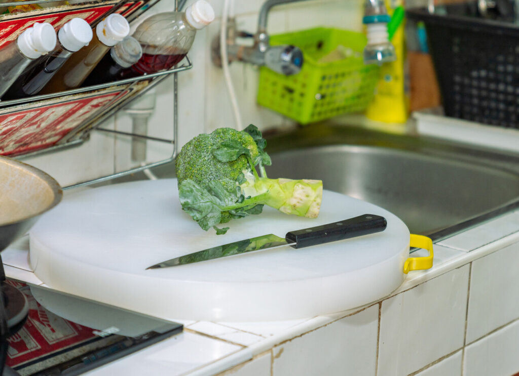 Close-up of a cutting board resting securely over a kitchen sink