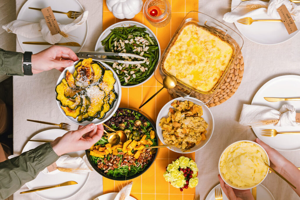 Colorful Harvest Feast Displayed on a Thanksgiving Dining Table With Friends Enjoying Together in Autumn