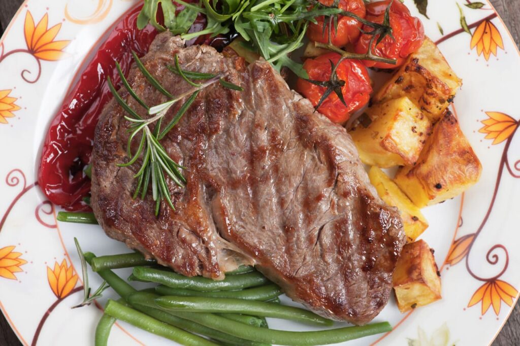 Beef rib-eye steak with roasted potato and vegetables
