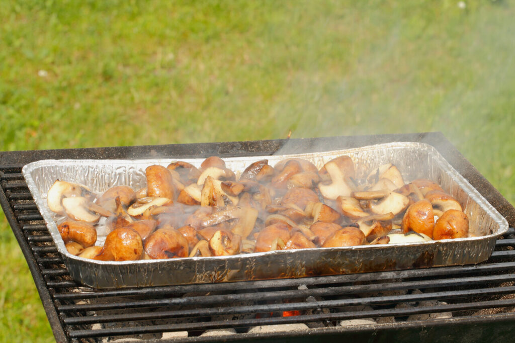 Grilled mushrooms and onions on a flat-top grill