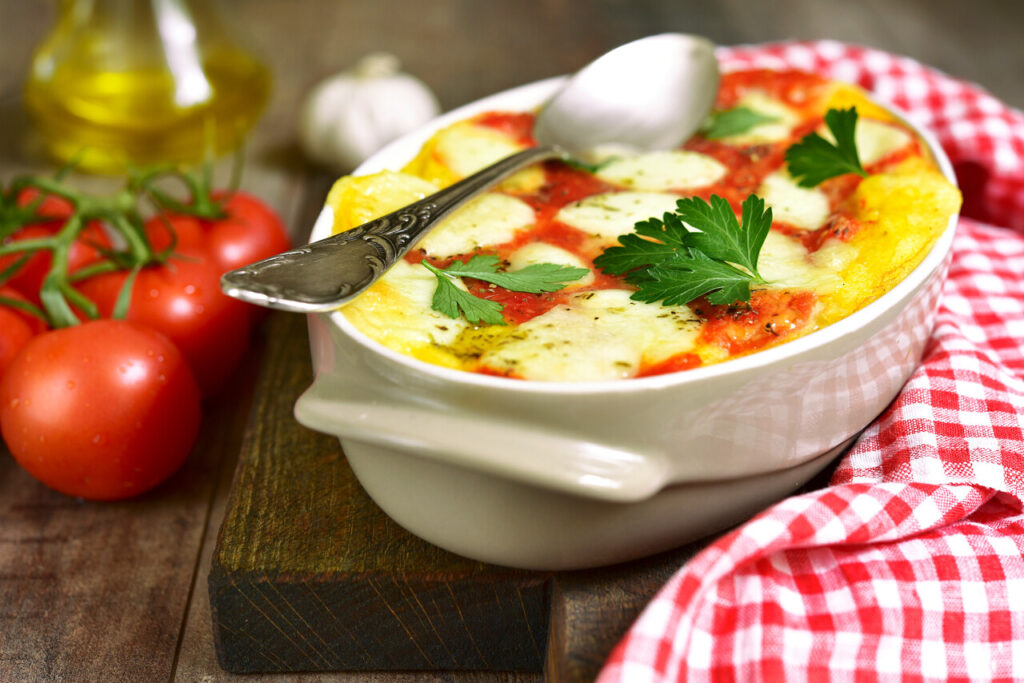 Polenta baked with tomato and cheese.