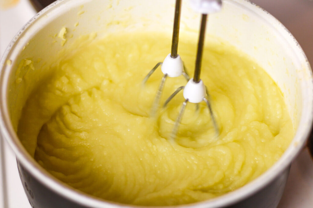 Someone using a stand mixer on mashed potatoes