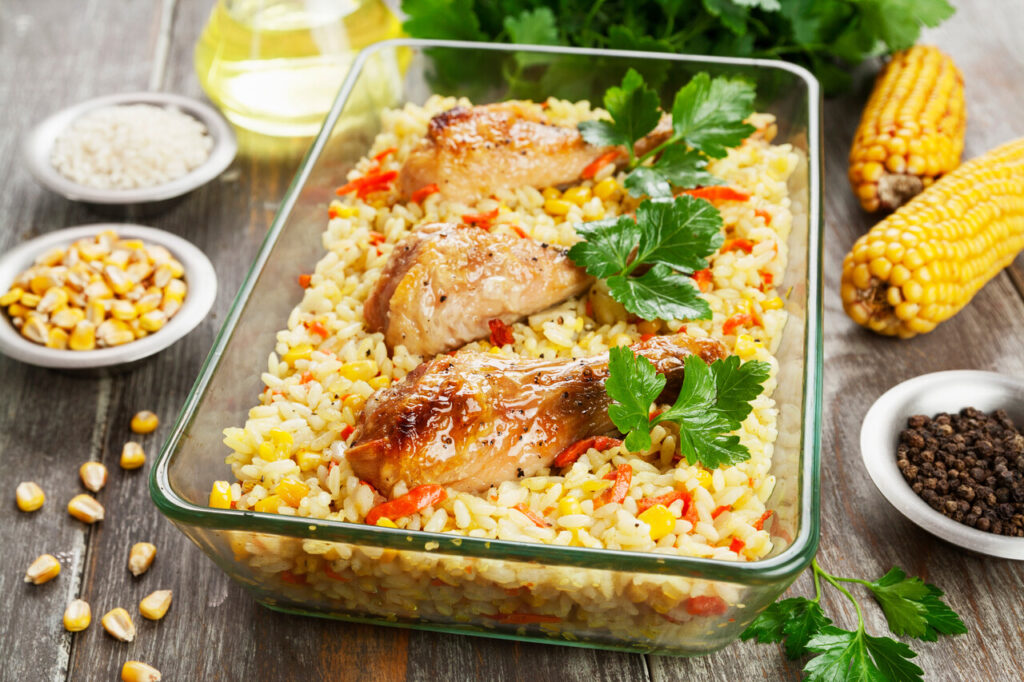 Chicken legs baked with rice and vegetables on the table