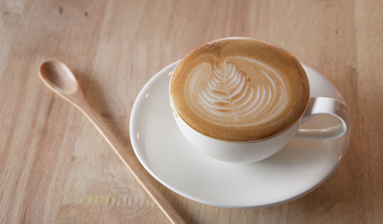Hot milk art coffee on wooden table